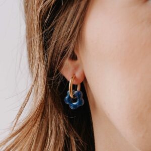 Boucles d’oreilles Créoles Mini Oia - Bleu en résine bleu marine et anneau doré portées à l’oreille