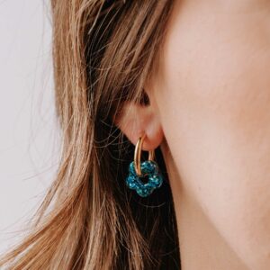 Boucles d’oreilles Créoles Mini Oia - Luz en résine bleue pailletée et anneau doré portées à l’oreille