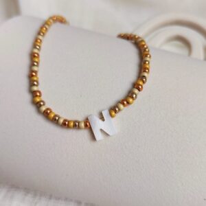 Collier Sand initiale avec perles dorées et champagne en Miyuki et lettre en nacre blanche élégante