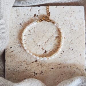 Bracelet Hossegor composé de véritables perles d'eau douce blanches avec fermoir doré réglable.