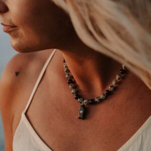 Collier Chania en jaspe dalmatien et grenat avec pendentif poisson en obsidienne noire serti d'un oxyde de zirconium.