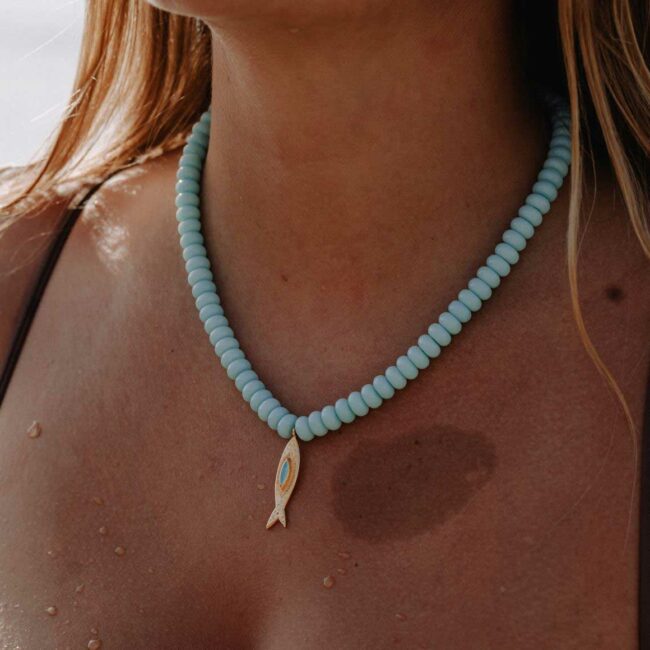 Collier Tarifa en perles Heishi bleu ciel avec pendentif poisson doré à l'or fin et détail turquoise.
