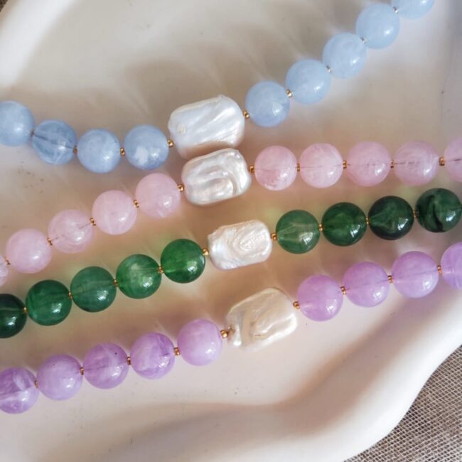 Collier Javea en perles colorées avec perle d'eau douce centrale, disponible en bleu, rose, émeraude et lilas.