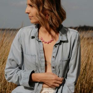 Collier Sabrina porté avec plusieurs cœurs roses en résine et fine chaîne dorée
