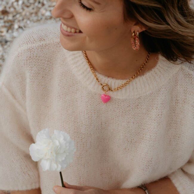 Collier Alexandra porté avec chaîne dorée et pendentif cœur rose en résine