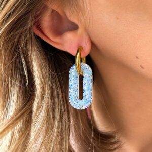 Créoles Josy Moon portées avec pampille rectangle en résine blanc givré aux reflets bleus irisés